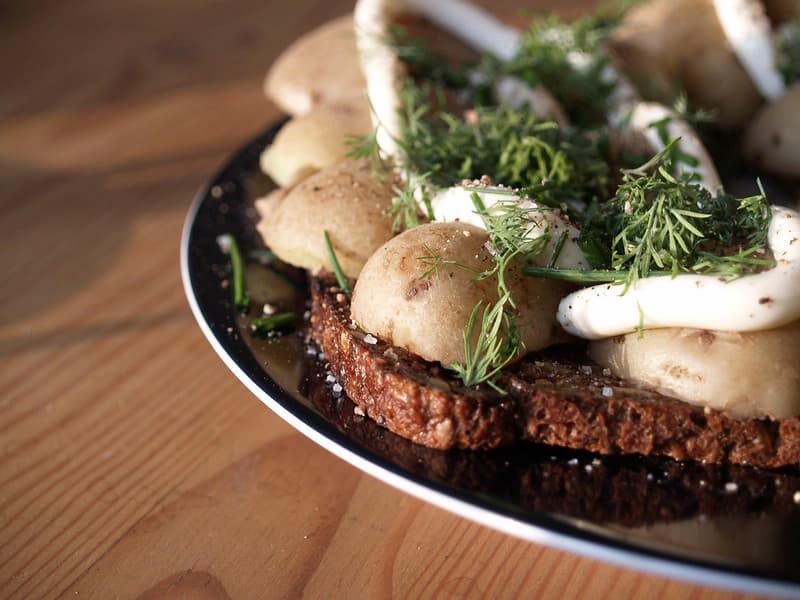 mayonnaise in a cup being shown with spoon